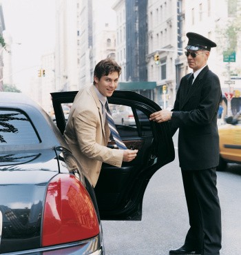 Chauffer Opening the Door of Car for a Young CEO in Manhattan, New York, USA